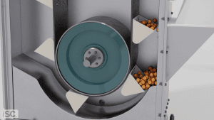 A mechanical device with a rotating wheel and triangular scoops—like ISC Bucket Elevators—provides reliable solutions for vertical conveying, moving small orange spheres from a lower compartment to upper trays.